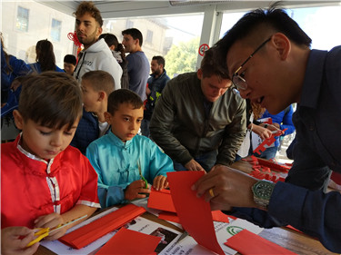 观众在孔院教师指导下学习剪纸.jpg