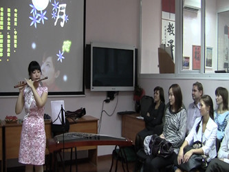 图片1：志愿者张沁涵老师展示民族乐器.jpg.PNG